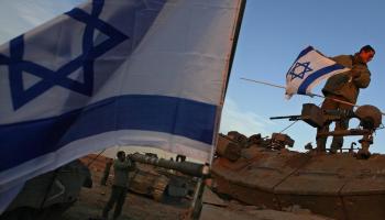 Un soldat jueu instal·lant la bandera israeliana al seu tanc, per iniciar el camí al centre de Gaza. Foto: Reuters.