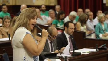 La consellera Camps, durant el seu torn de paraula. A fora, milers de veus clamen per la retirada del TIL.