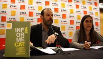 Exemplar de l'Informe Cat 2016, en primer terme, amb el president i la directora de Plataforma per la Llengua, Òscar Escuder i Neus Mestre, al darrere. Aquest dimarts 3 de maig (HORITZONTAL)