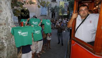 Un grup de persones mostra les camisetes verdes al pas del comboi en el qual viatjava el president Bauzá durant la celebració del centenari del tramvia de Sóller celebrat divendres.