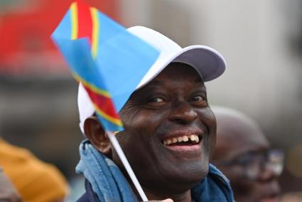 Un home amb una bandera del Congo en una manifestació per a reclamar la pau.