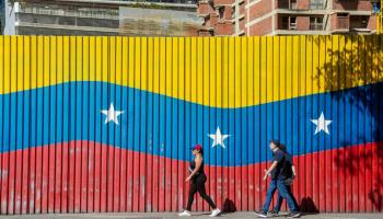 Imatge d'una gran bandera de Veneçuela pintada en una tanca de Caracas.