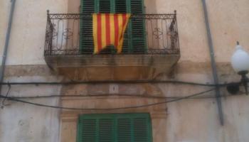 Senyera penjada a una balconada mallorquina contra tots els atacs a la llengua pròpia.