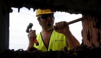 Un operari desmuntant una casa il·legal. 