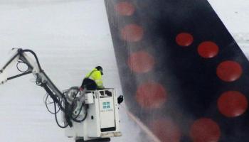 Un operador tracta de mantenir en bon estat una part de l'aeronau, afligida per l'intens fred de desembre.