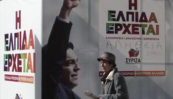 Una dona passa al costat d'un cartell del partit d'Alexis Tsipras a Atenes. 